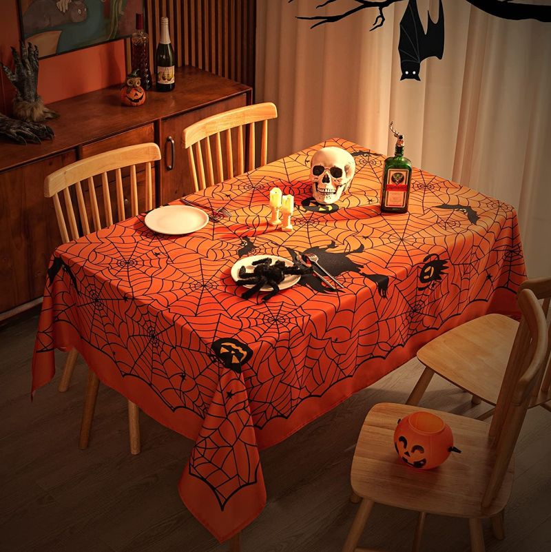 Orange rectangular tablecloth featuring printed spider webs